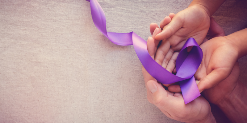 Image of hands with purple ribbon